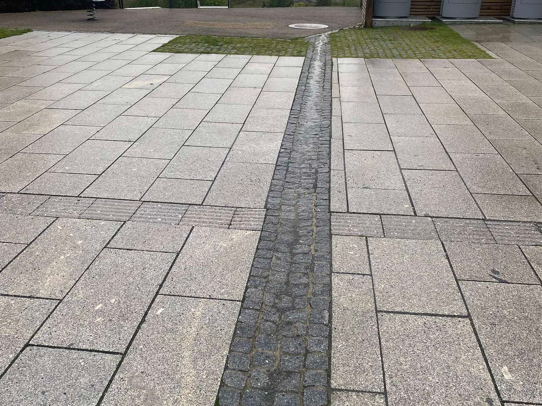 Dekke av granittheller med renne som leder bort overvann