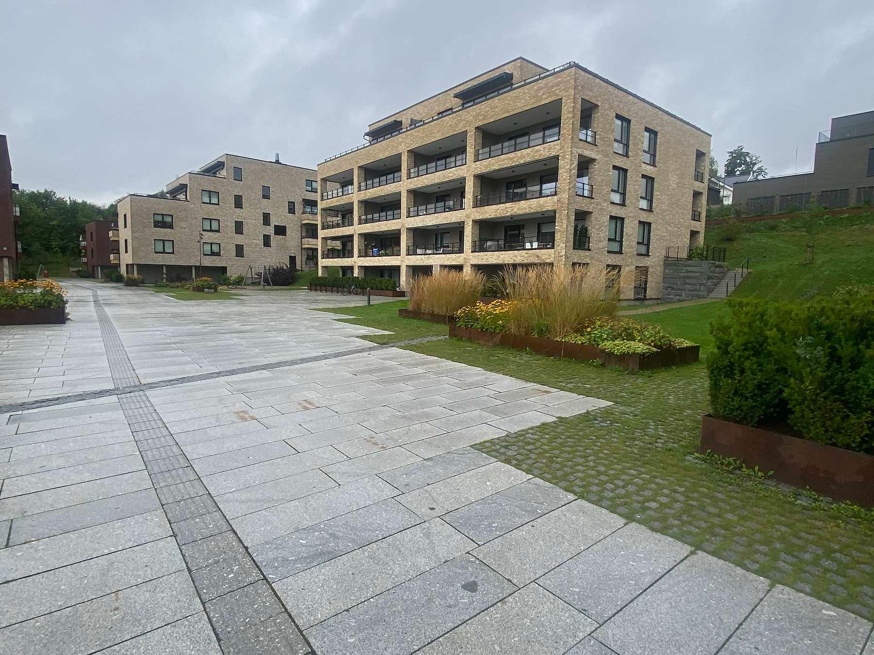 Opparbeidet uteområde med steindekke og beplantning i boligprosjekt